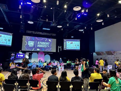 Student voices event taking place, with youth sat in large circle talking amongst themselves.